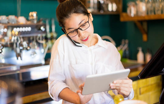 waitress looking at tablet - increase restaurant bookings